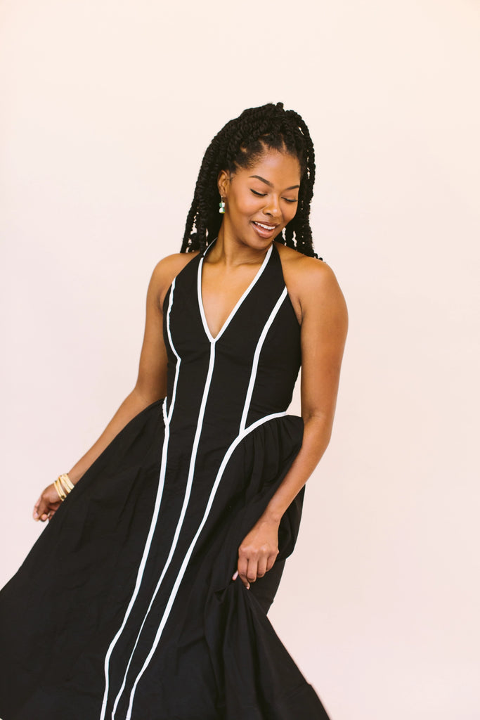 Woman wearing green, white, and gold hourglass statement earrings, handmade locally in Charlotte, NC (North Carolina), at a Plaza Midwood woman owned jewelry art and home decor gift shop. A can't miss thing to do - order a housemade vegan chai at The Chai Window to sip while you shop. 