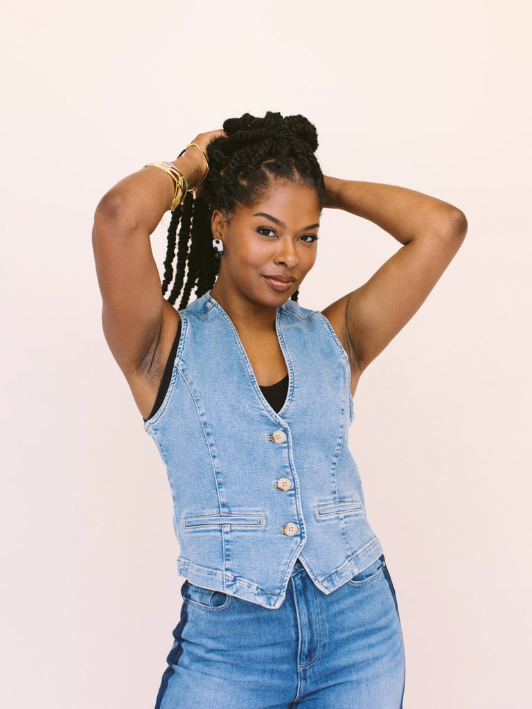 Woman wearing square earrings with black spots on a white porcelain background, handmade locally in Charlotte, NC (North Carolina), at a Plaza Midwood woman owned jewelry art and home decor gift shop. A can't miss thing to do - order a housemade vegan chai at The Chai Window to sip while you shop. 