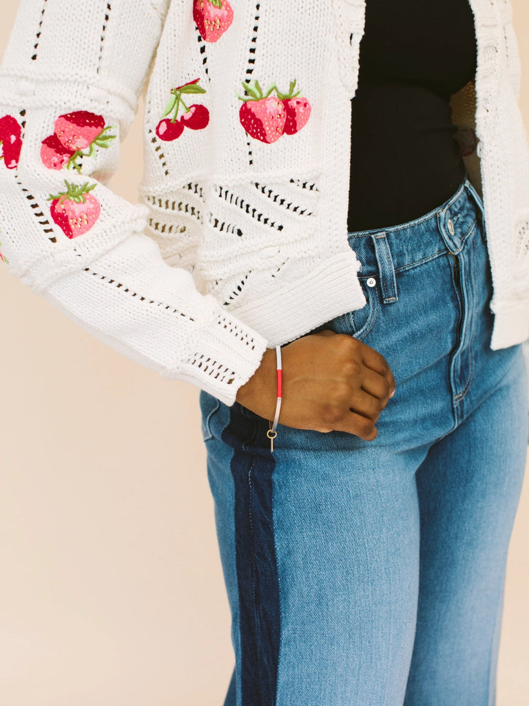 Woman wearing wrapped bangles that can be stacked/layered and worn together, handmade locally in Charlotte, NC (North Carolina), at a Plaza Midwood woman owned jewelry art and home decor gift shop. A can't miss thing to do - order a housemade vegan chai at The Chai Window to sip while you shop. 