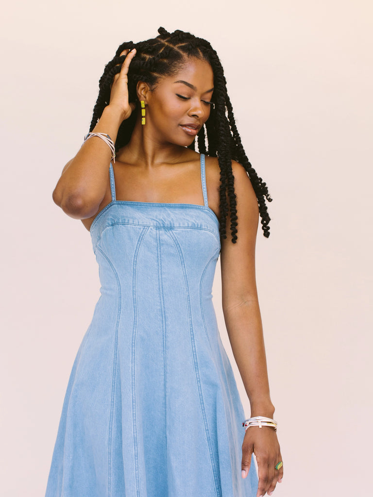 Woman wearing statement earrings in gold with green splatter, handmade locally in Charlotte, NC (North Carolina), at a Plaza Midwood woman owned jewelry art and home decor gift shop. A can't miss thing to do - order a housemade vegan chai at The Chai Window to sip while you shop. 