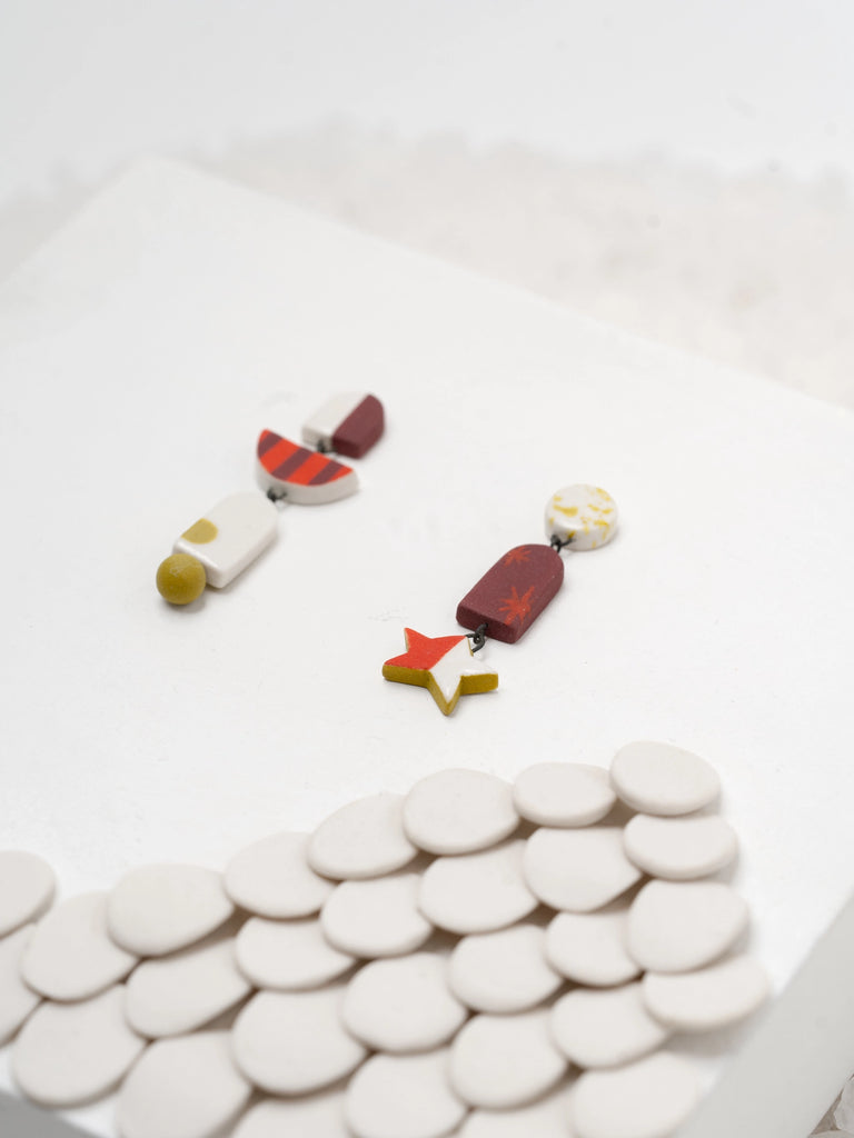 Dangling stud earrings with stars, circles, and more shapes, handmade locally in Charlotte, NC (North Carolina), at a Plaza Midwood woman owned jewelry art and home decor gift shop. A can't miss thing to do - order a housemade vegan chai at The Chai Window to sip while you shop. 